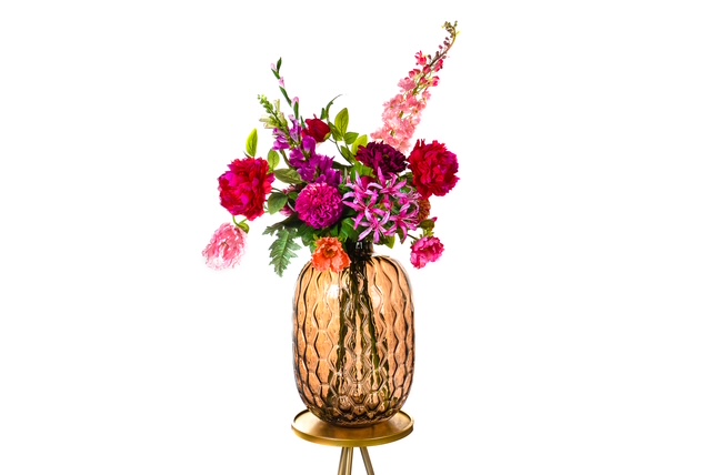 Zijden bloemstuk in rood en roze in een glazen vaas
